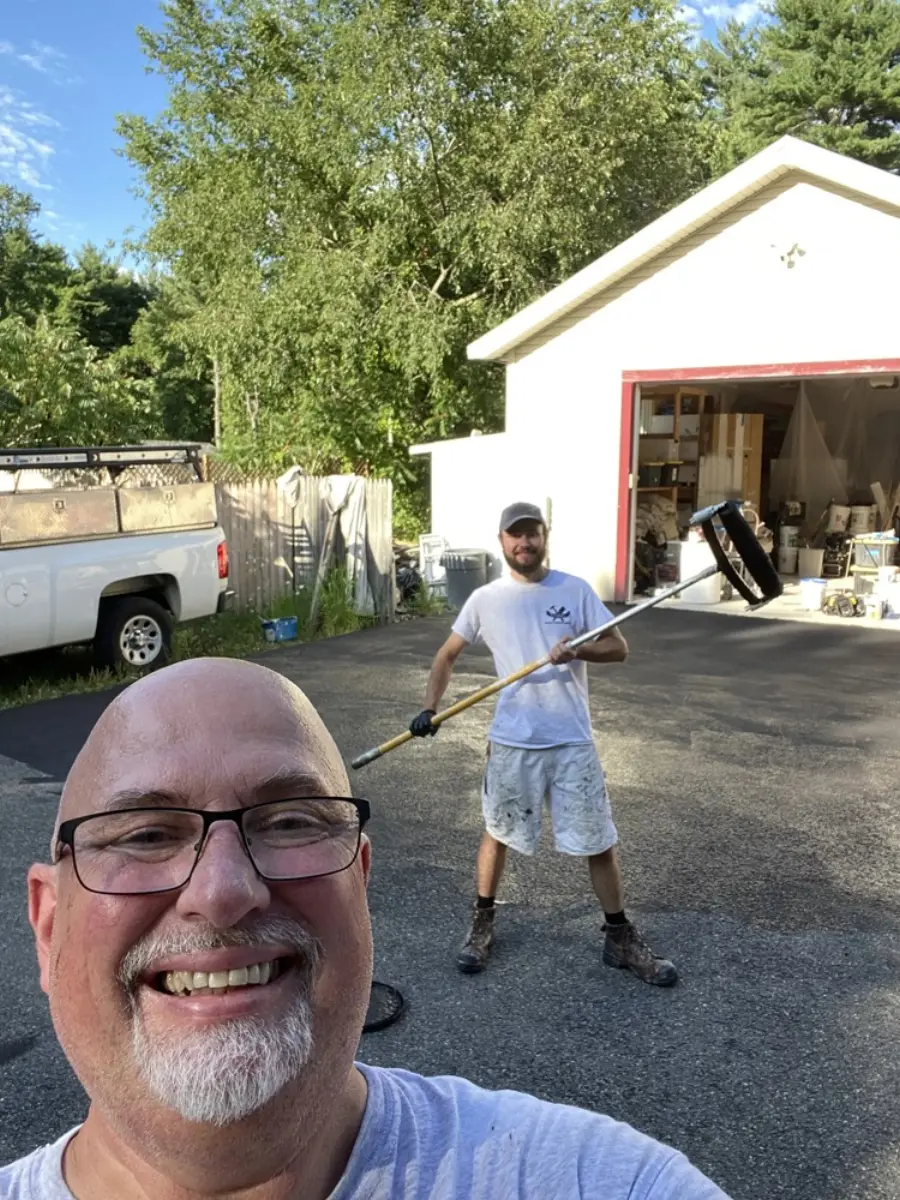 Smiling Sorel family member in a selfie with a crew member rolling paint behind him