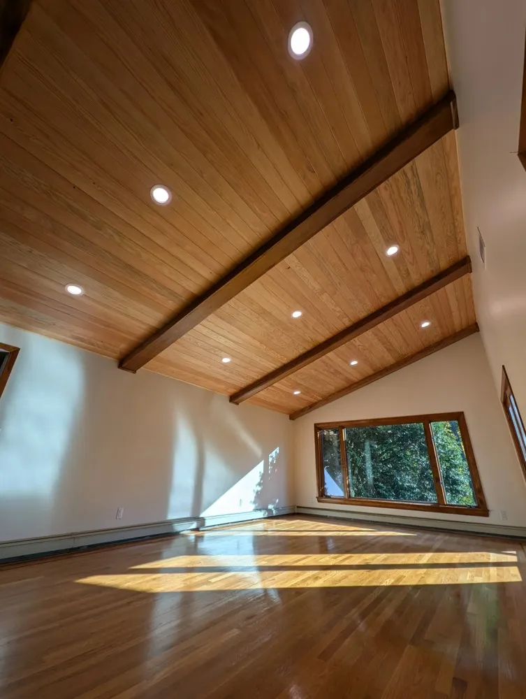 Den with a new wood plank vaulted ceiling and beams