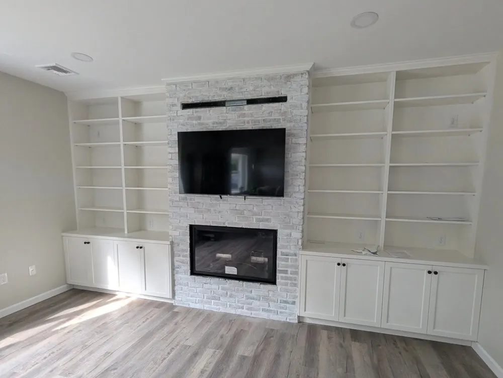 Living room with built-in bookshelves and a stone fireplace